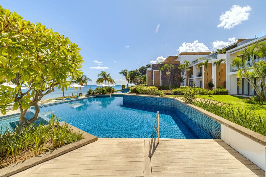 Immerse yourself in the luxurious ambiance of Cap Ouest Mauritius with this inviting image of our expansive, multi-level swimming pool. Offering stunning views of the Indian Ocean, this pool area is surrounded by beautiful tropical gardens and the contemporary architecture of the resort. Perfect for a refreshing swim or lounging in the Mauritian sunshine, it highlights the exceptional amenities available for a relaxing and memorable stay.